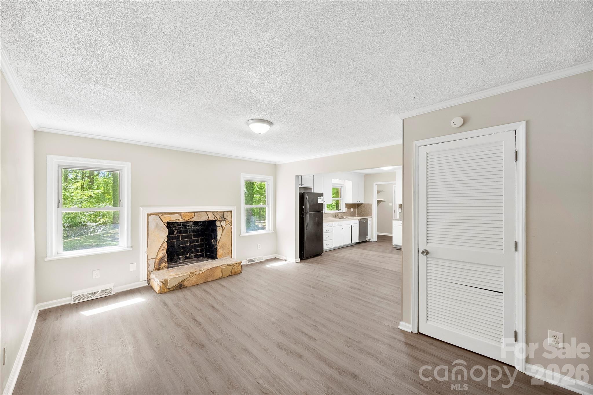 7001 Crossridge Road Charlotte, NC 28214 - Photo 25 of 30 an empty room with wooden floor fireplace and windows