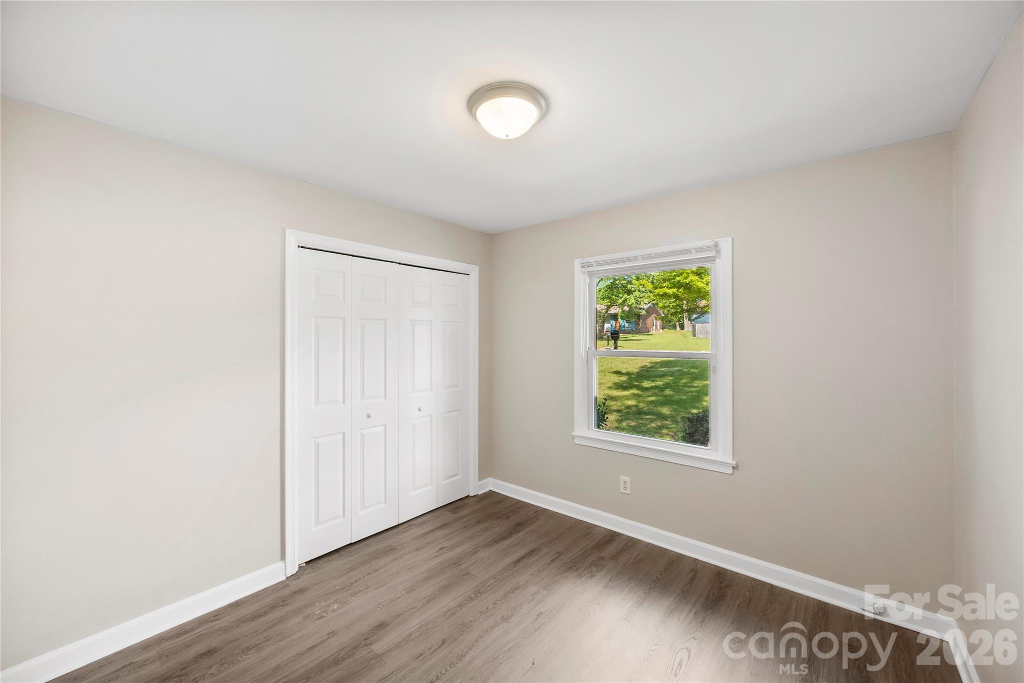 7001 Crossridge Road Charlotte, NC 28214 - Photo 28 of 30 a view of an empty room with wooden floor and a window