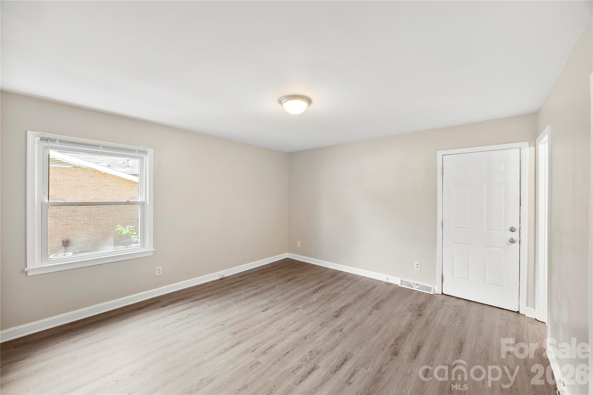 7001 Crossridge Road Charlotte, NC 28214 - Photo 4 of 30 an empty room with wooden floor and windows