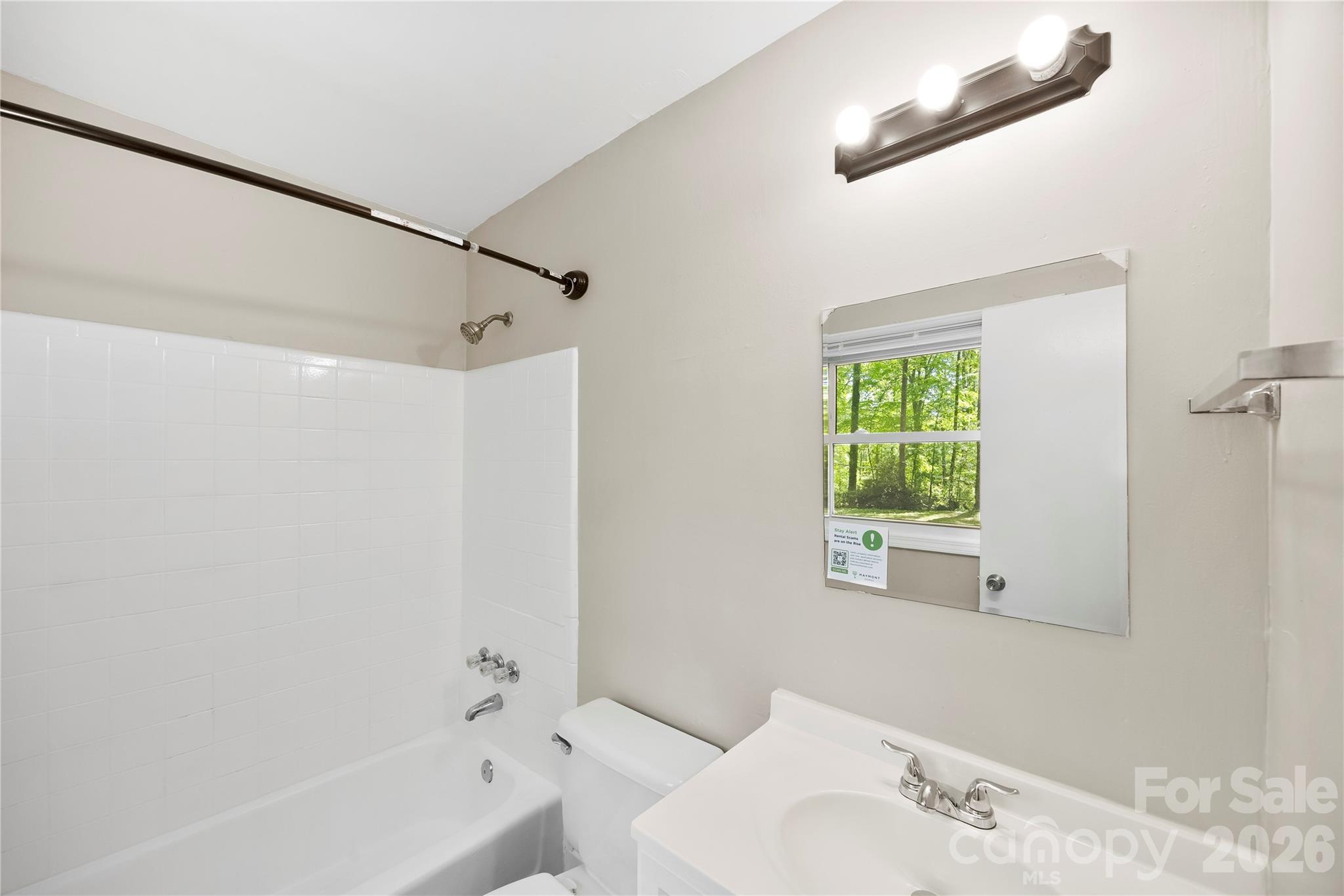 7001 Crossridge Road Charlotte, NC 28214 - Photo 5 of 30 a bathroom with a bathtub a window and a shower