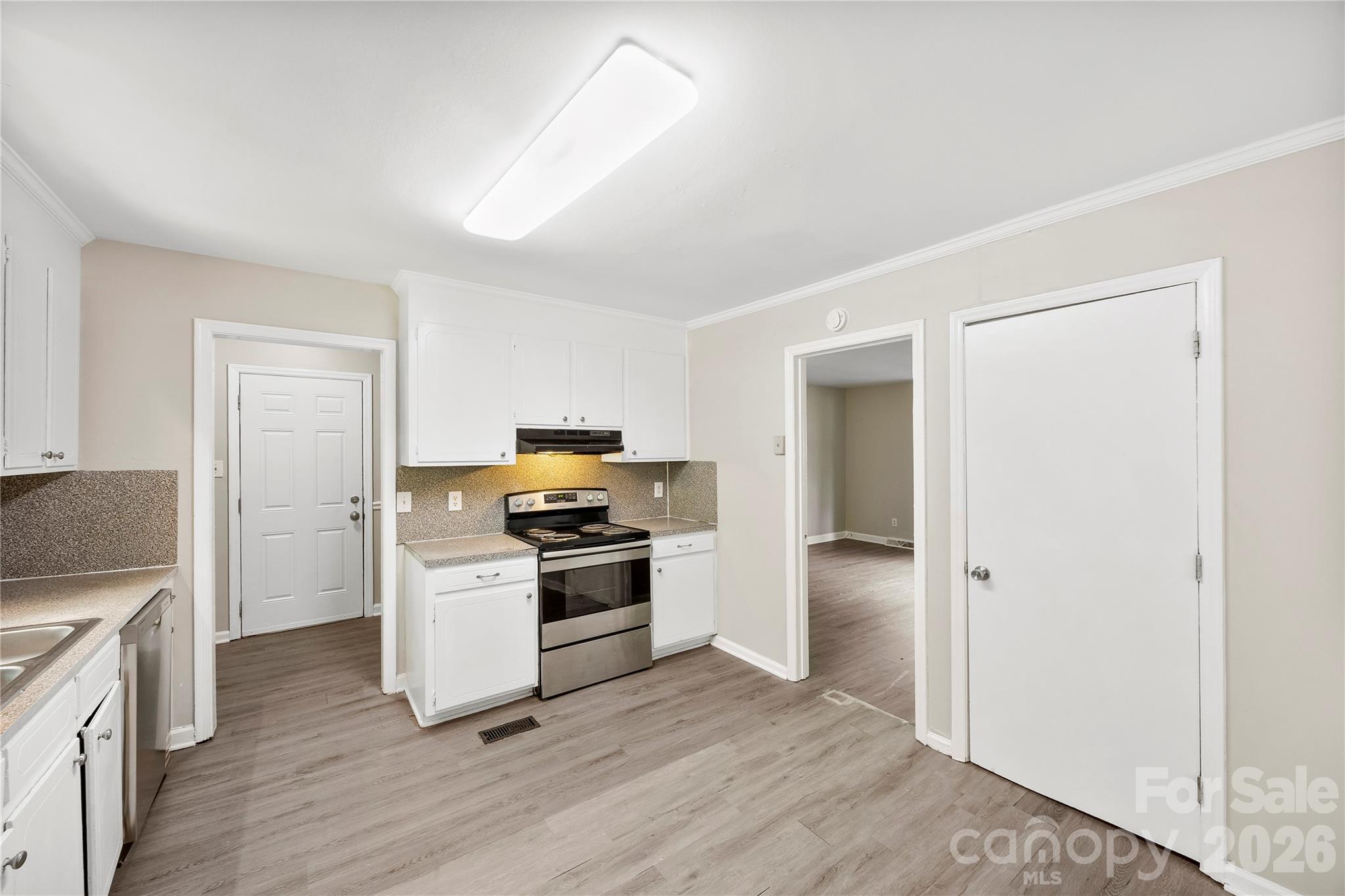 7001 Crossridge Road Charlotte, NC 28214 - Photo 7 of 30 a kitchen with a refrigerator stove and wooden floor