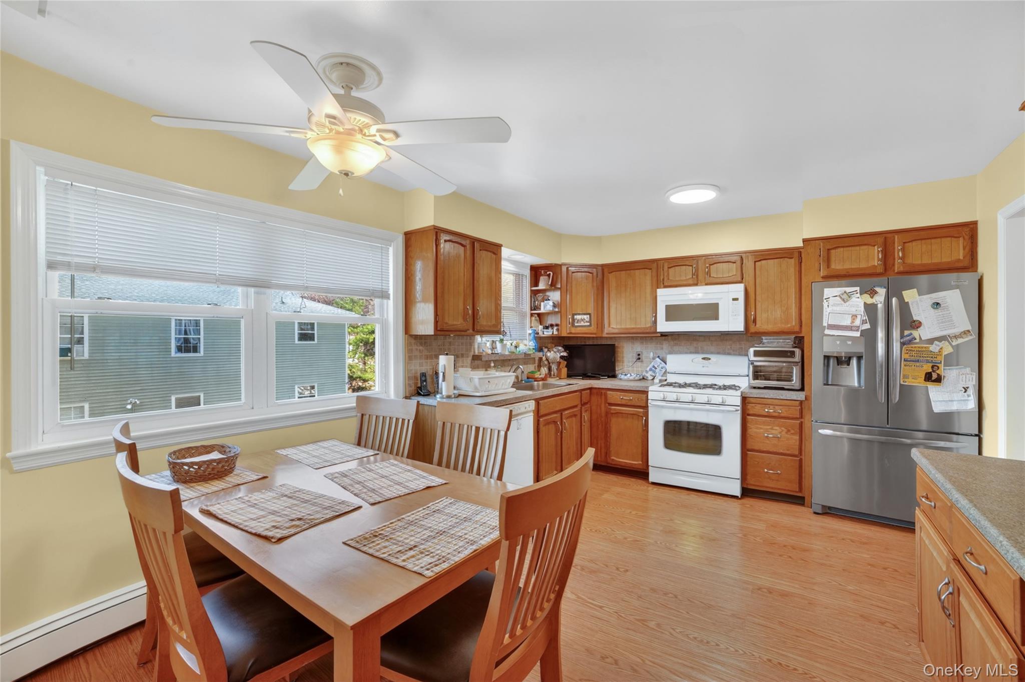 276 5th Avenue New Rochelle, NY 10801 - Photo 12 of 40 a kitchen with a refrigerator a stove a sink a dining table and chairs