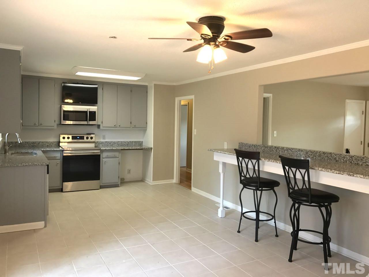 111 Barclay Road Durham, NC 27712 - Photo 4 of 21 a kitchen with a table chairs refrigerator and cabinets