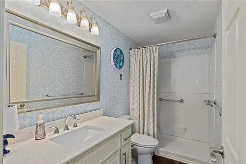 a bathroom with a sink a toilet and shower