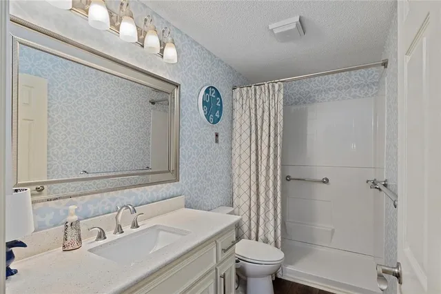 a bathroom with a sink a toilet and shower