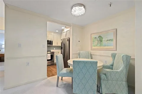 a living room with furniture a refrigerator and a dining table