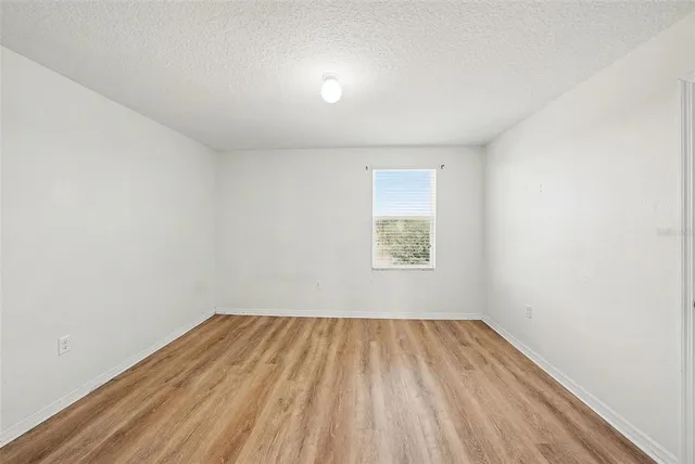 a view of a room with wooden floor and window