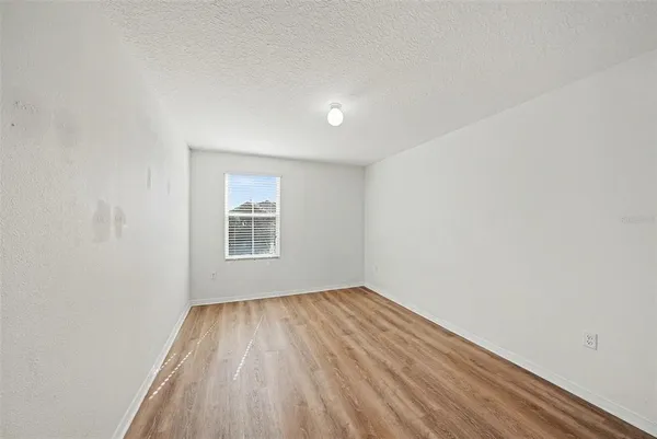 a view of a big room with wooden floor and windows