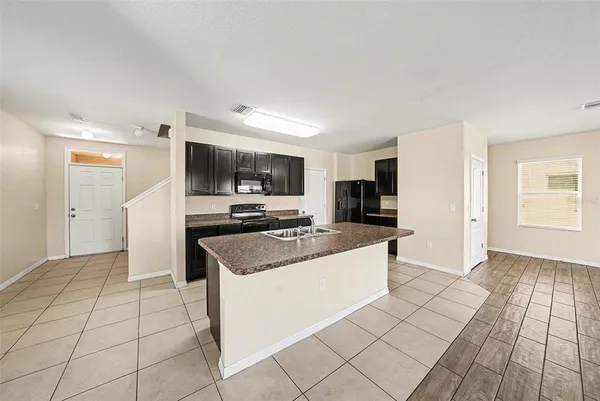 a kitchen with stainless steel appliances a sink a stove a microwave and cabinets