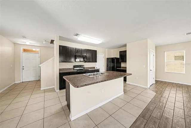 a kitchen with stainless steel appliances a sink a stove a microwave and cabinets