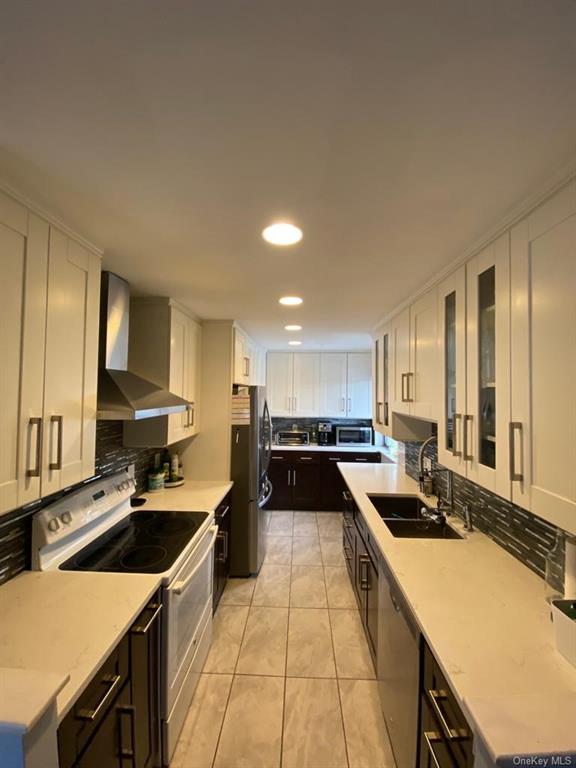 a kitchen with a sink a counter top space stainless steel appliances and cabinets