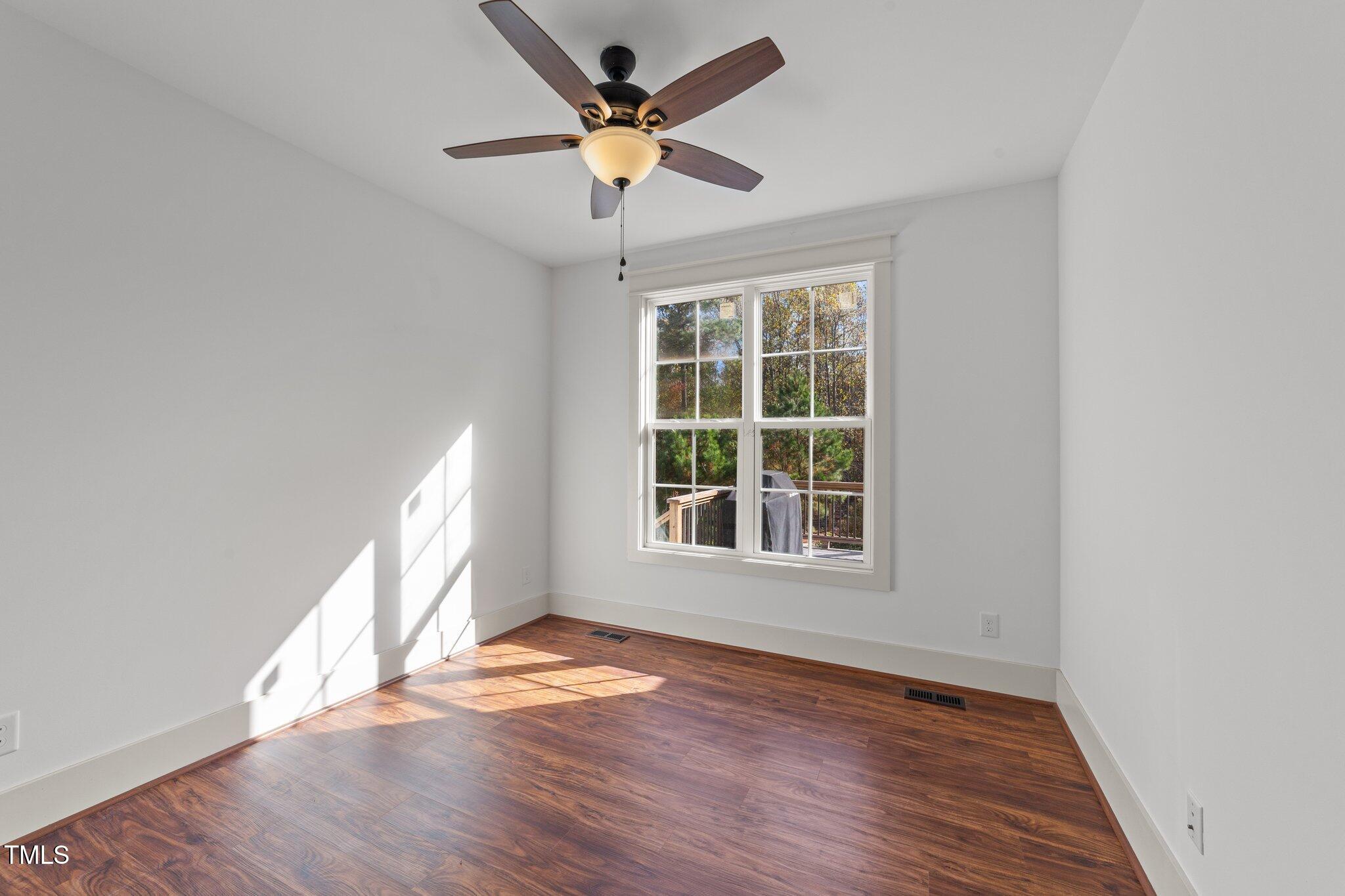 3820 Benson Hardee Road Benson, NC 27504 - Photo 19 of 55 an empty room with wooden floor and windows