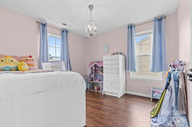 a bedroom with a bed and a chandelier