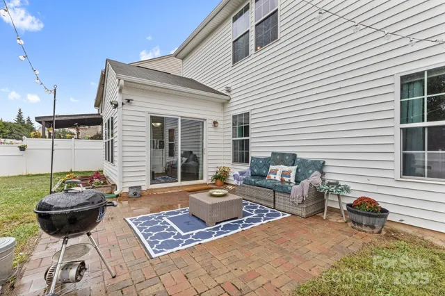 a view of a patio with couple chairs and a potted plant