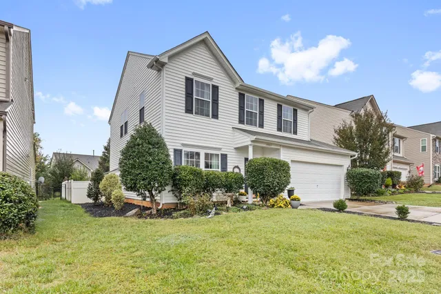 a backyard of a house with table and chairs and potted plants