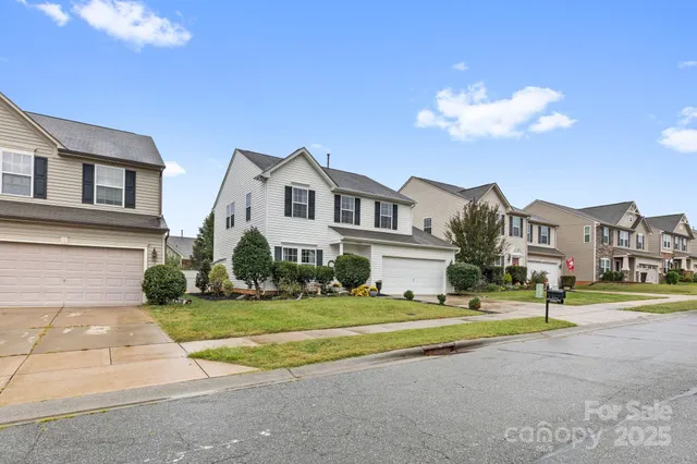 a view of a house with a big yard and large trees