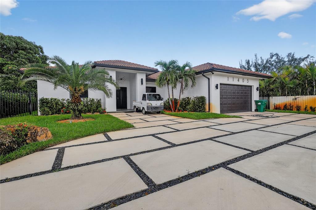 11405 East Golf Drive Miami, FL 33167 - Photo 2 of 25 a front view of a house with a yard and potted plants