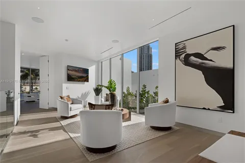 a living room with furniture and potted plants