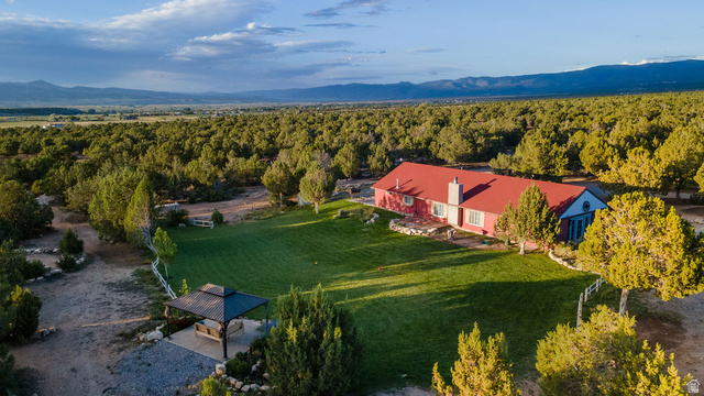 11550 Pigeon Hollow Road Spring City, UT 84662 - Photo 10 of 85 Expansive green lawn, surrounding mature trees, outdoor gazebo, distant mountain range, and a red-roofed residence