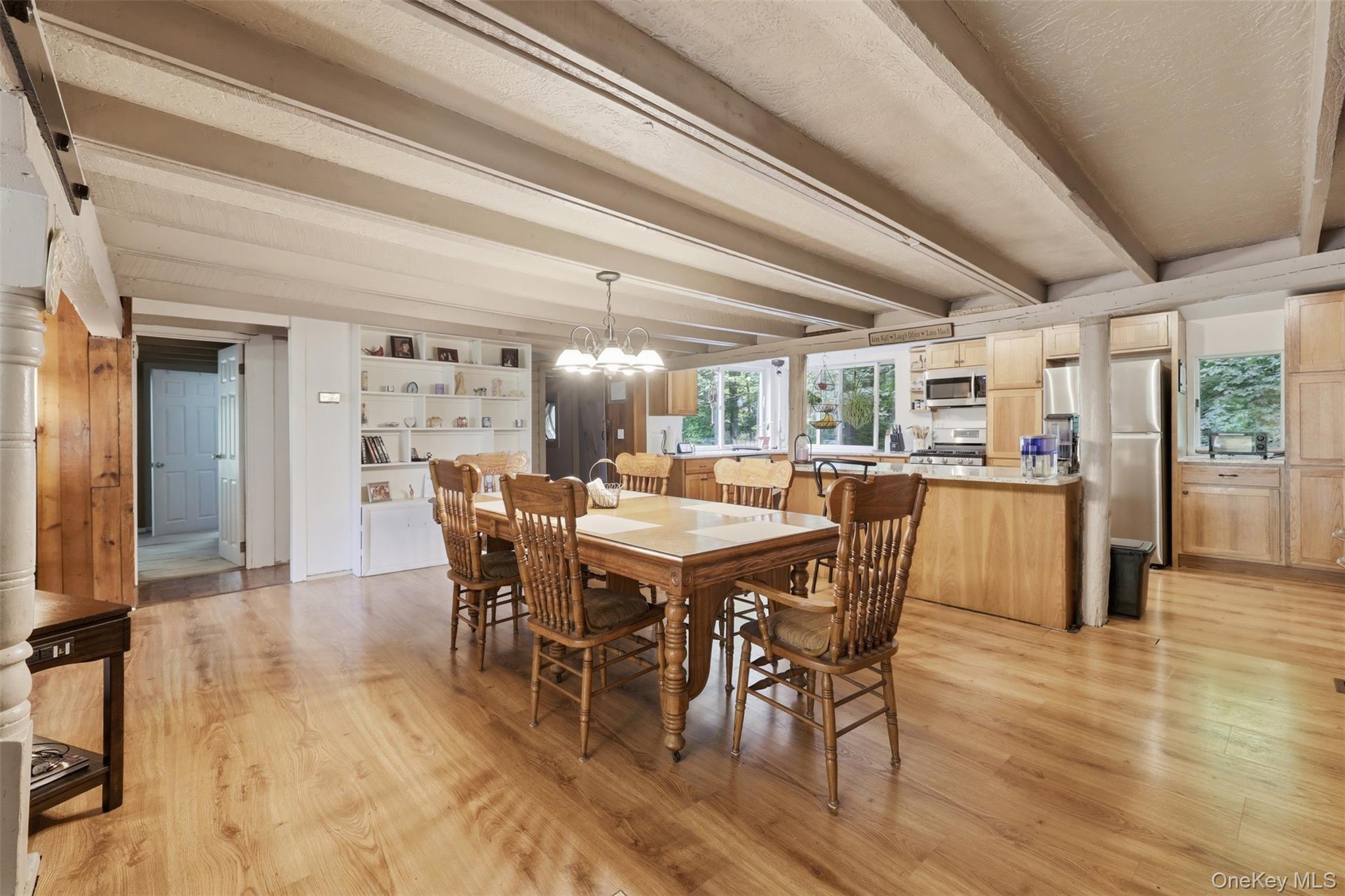 236 Hosner Mountain Road Hopewell Junction, NY 12533 - Photo 18 of 46 Expansive open-concept dining room featuring wood-finish flooring, exposed ceiling beams, and chandelier
