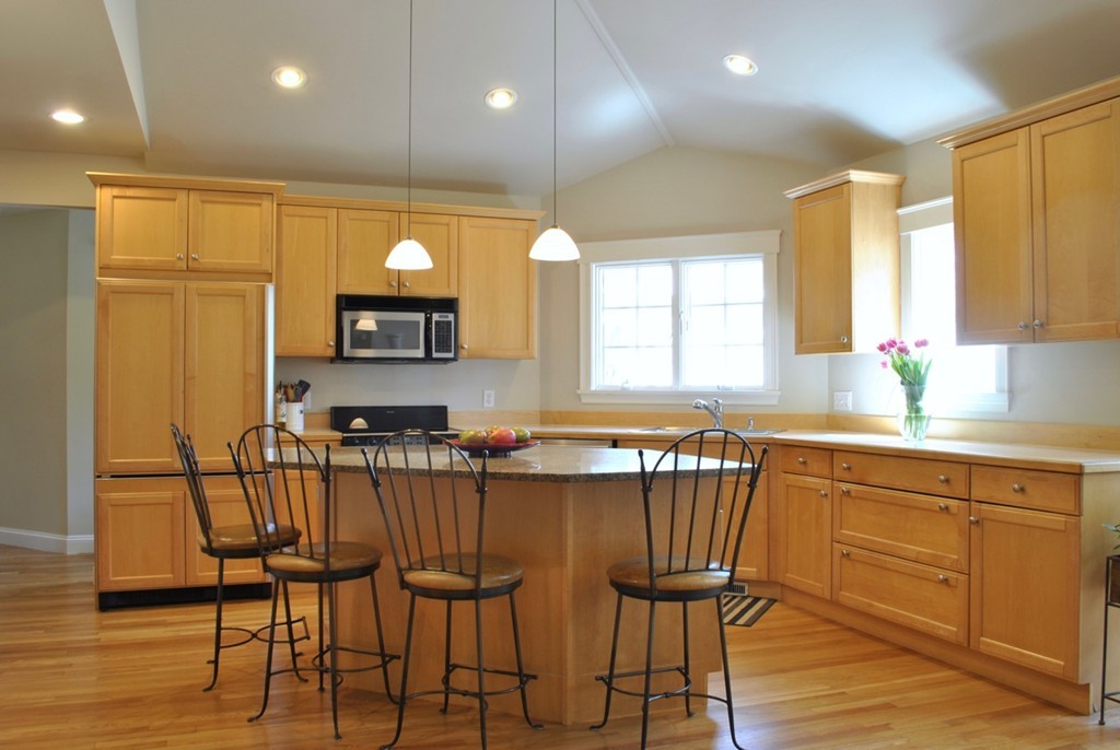 17 Giles Road Lincoln, MA 01773 - Photo 7 of 18 a kitchen with granite countertop a table chairs stove microwave and cabinets