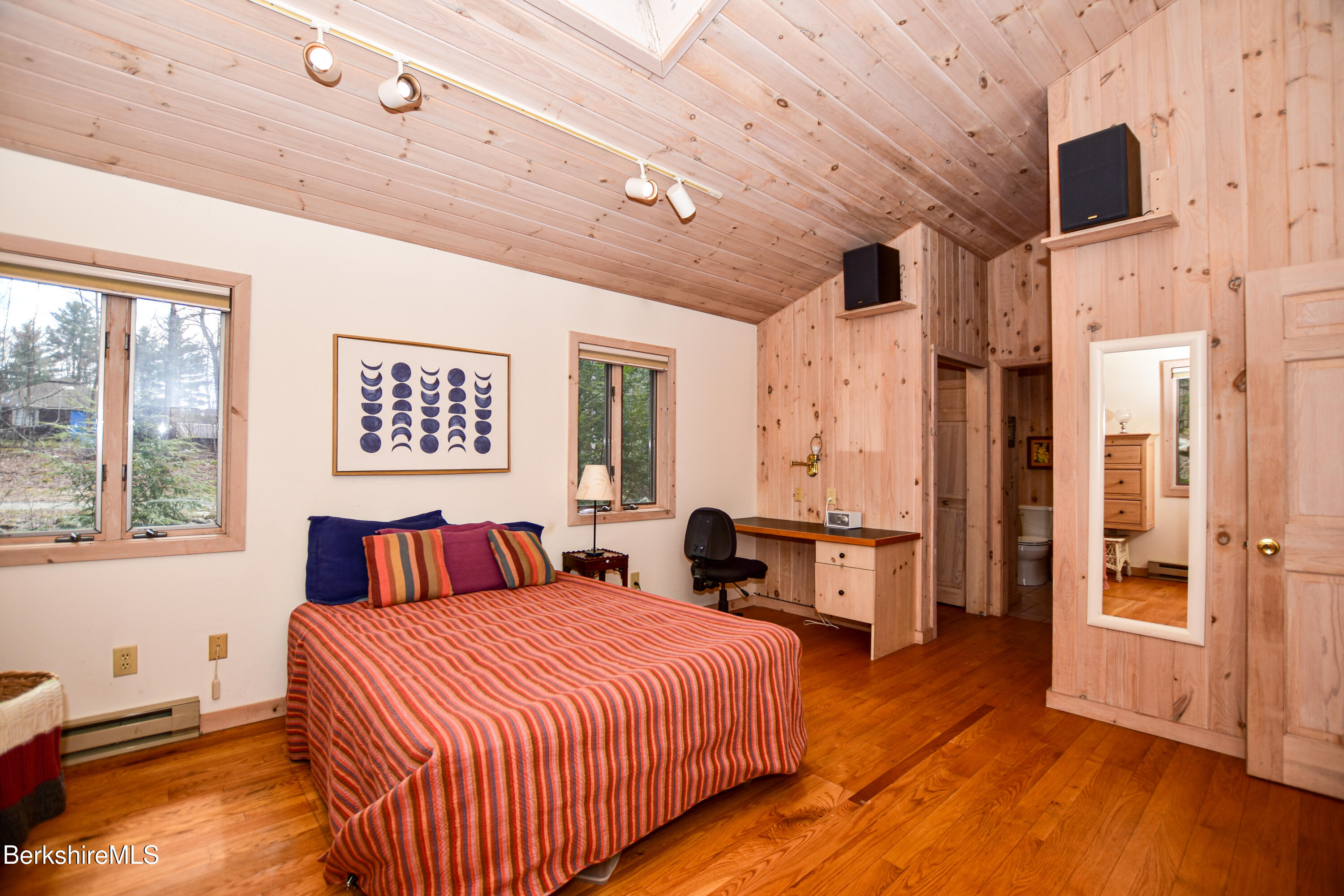 283 Benton Hill Road Becket, MA 01223 - Photo 15 of 55 a bedroom with a large bed and a chandelier