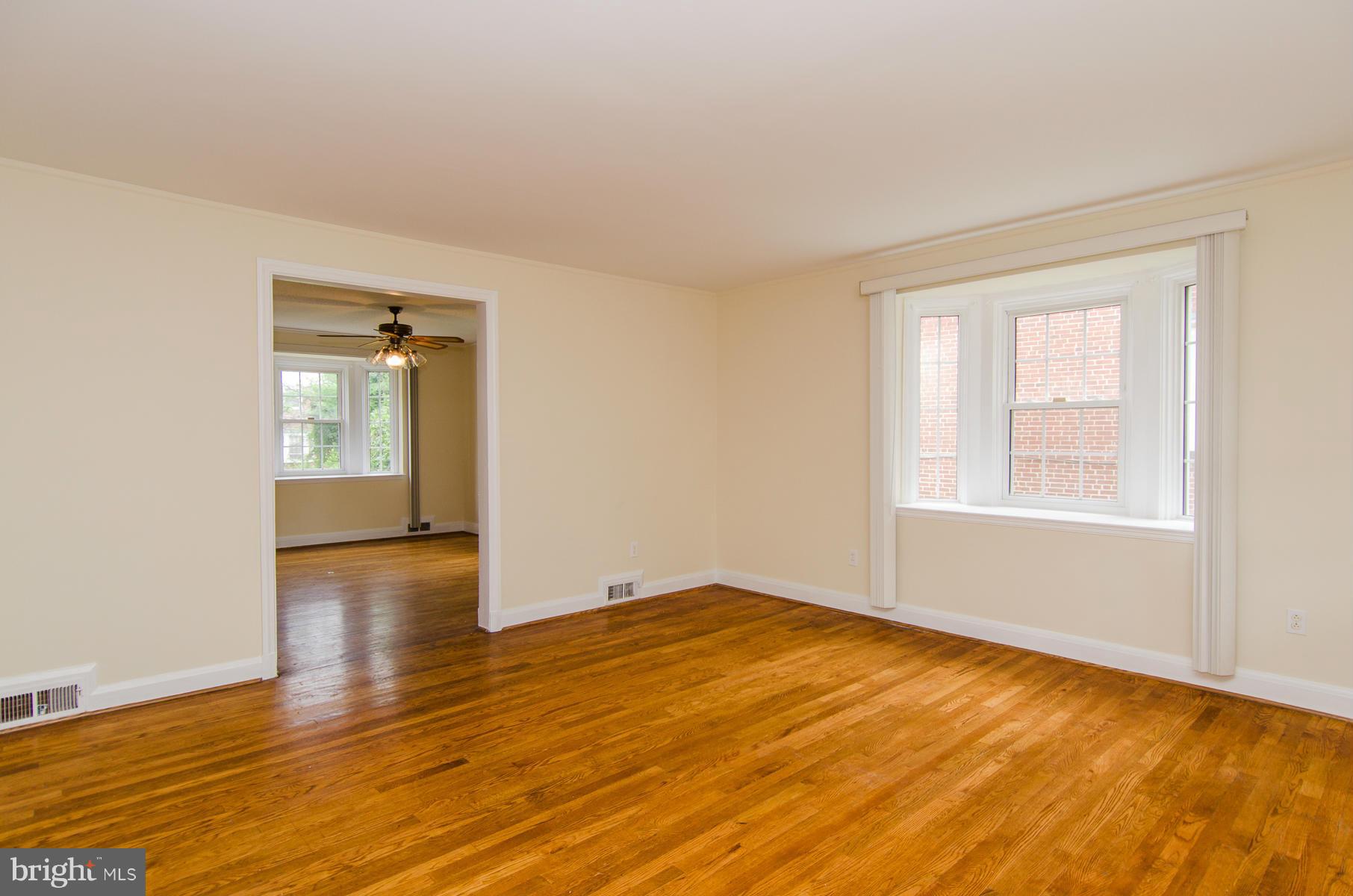 1417 Stonewood Road Baltimore, MD 21239 - Photo 2 of 28 an empty room with wooden floor and windows