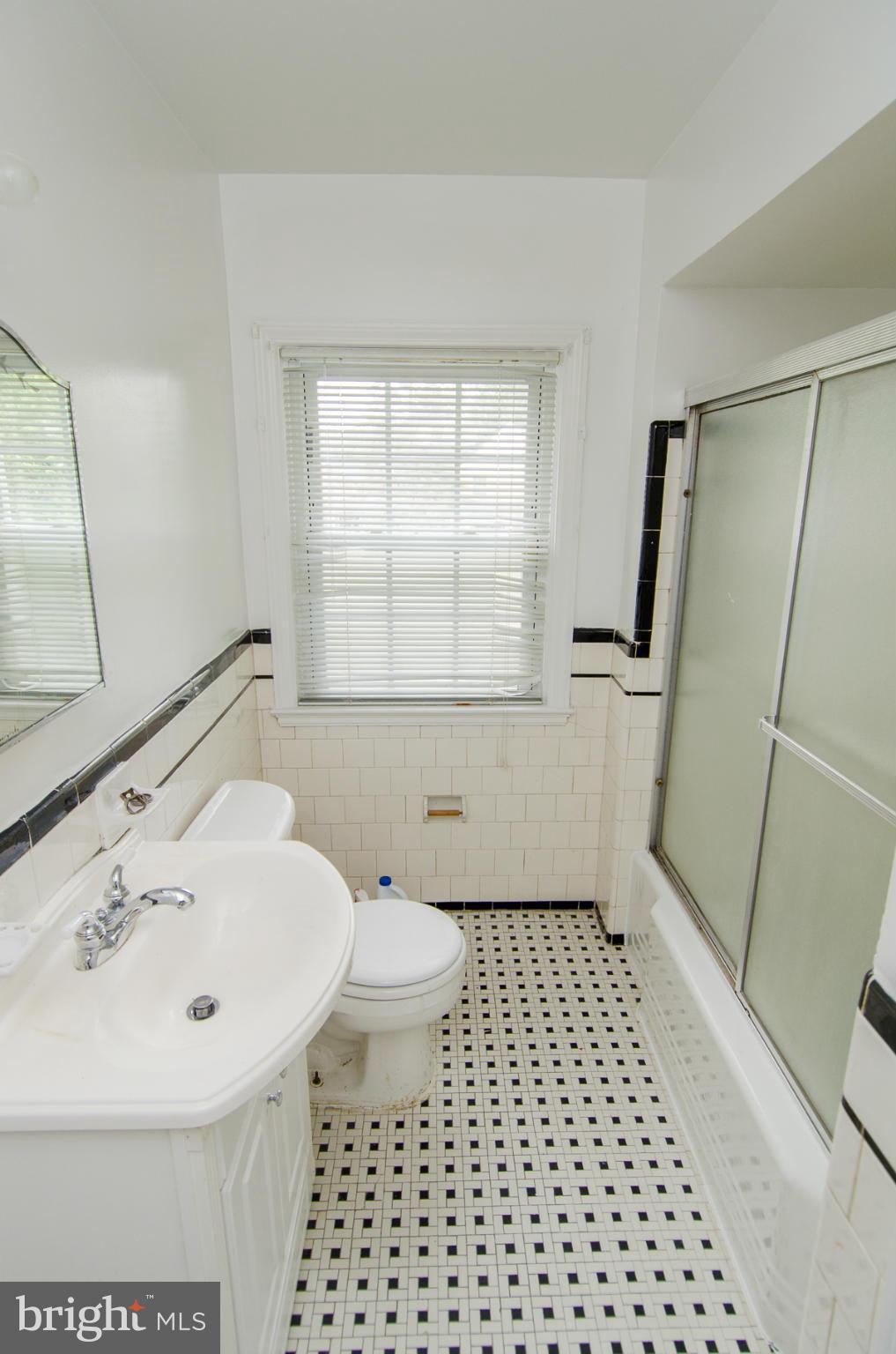 1417 Stonewood Road Baltimore, MD 21239 - Photo 11 of 28 a bathroom with a sink a toilet and a mirror