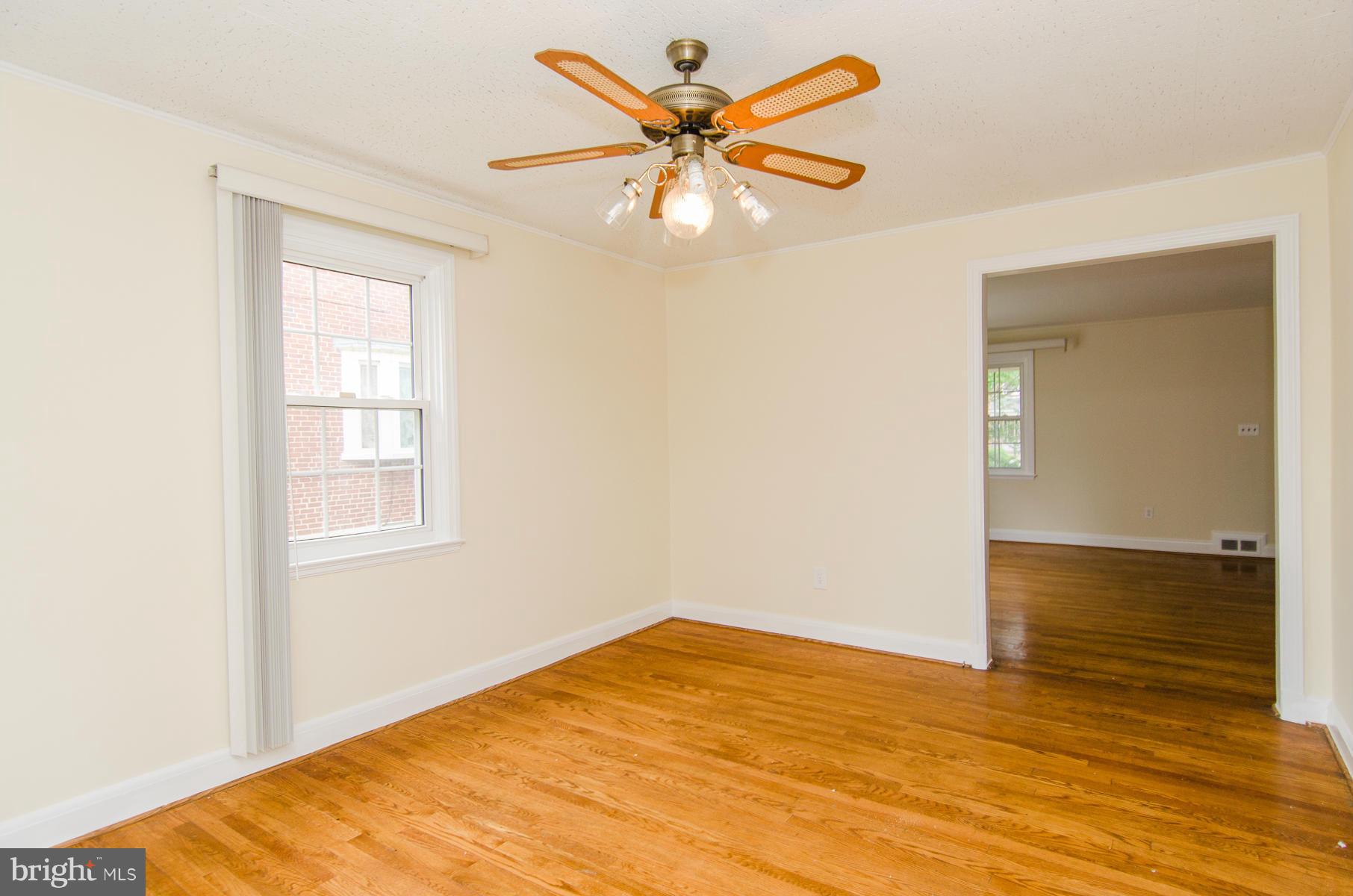1417 Stonewood Road Baltimore, MD 21239 - Photo 6 of 28 wooden floor in an empty room with a window