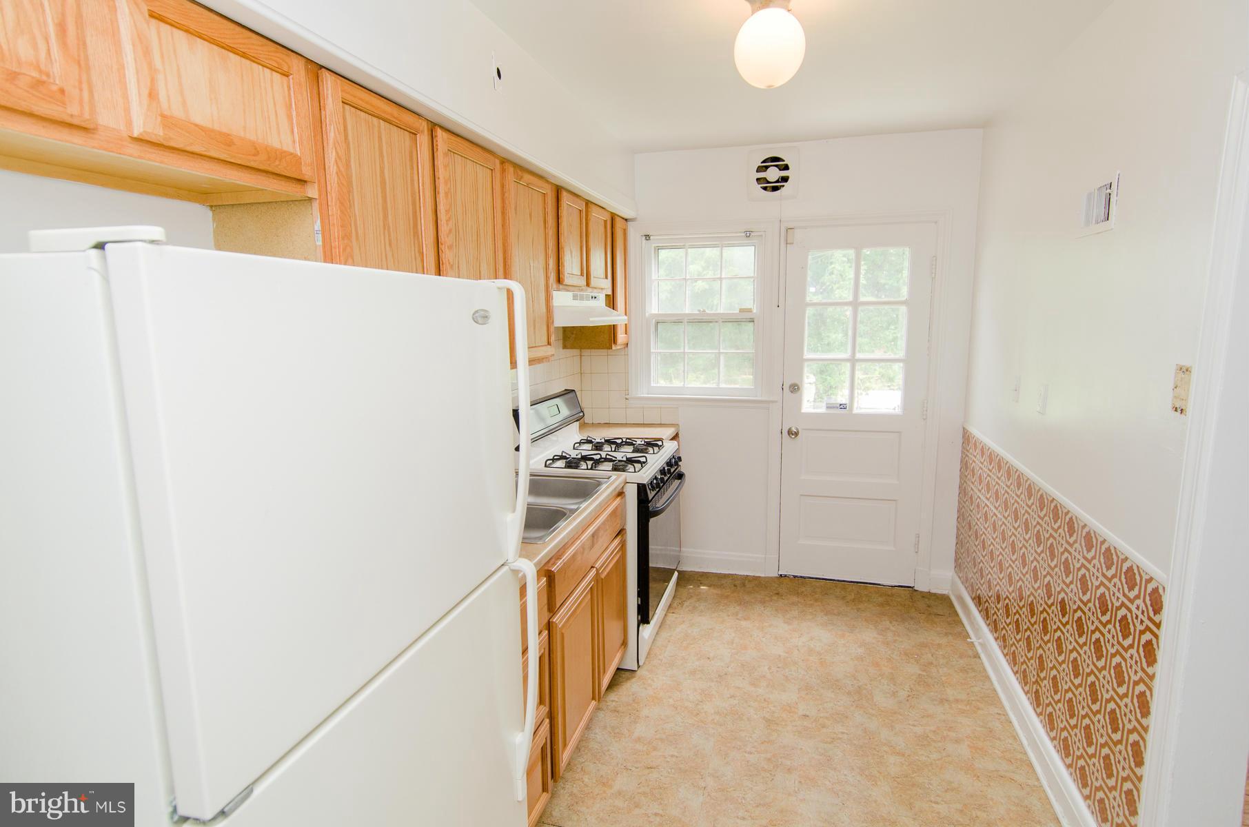 1417 Stonewood Road Baltimore, MD 21239 - Photo 7 of 28 a kitchen with a refrigerator a stove top oven