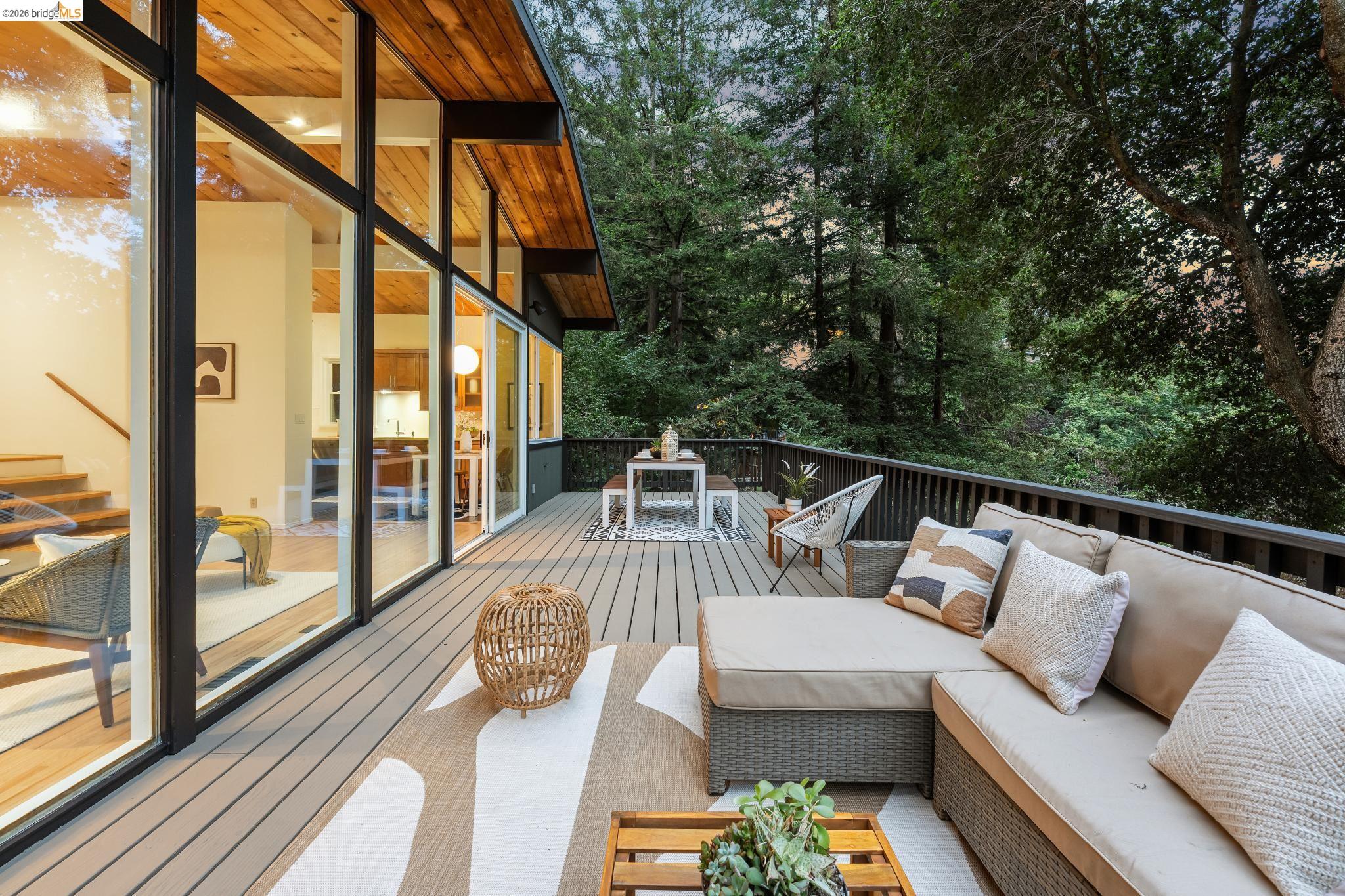 6645 Heather Ridge Way Oakland, CA 94611 - Photo 44 of 61 Expansive outdoor deck featuring wood-finish flooring, black railing, and surrounding mature trees