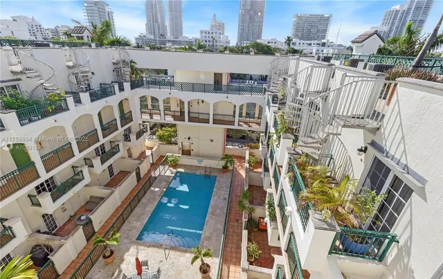 a patio with a table and chairs under an umbrella