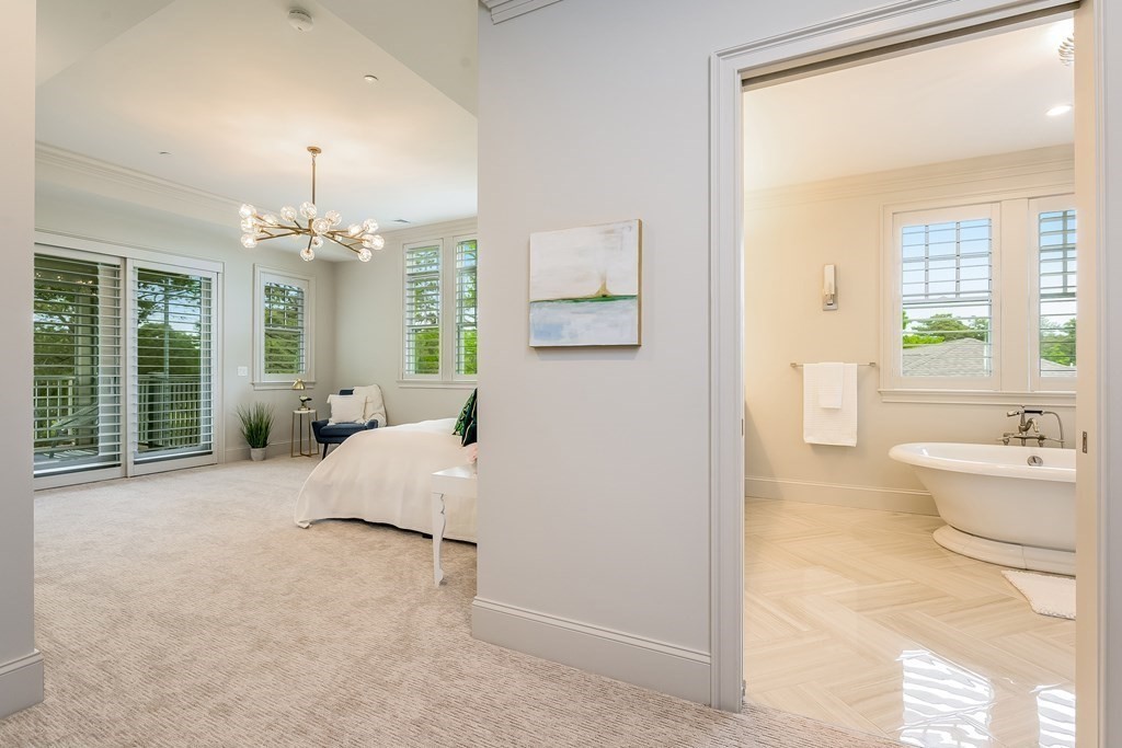 64 Simons Road, Unit F Mashpee, MA 02649 - Photo 14 of 33 a spacious bedroom with a bed and glass walk in closet