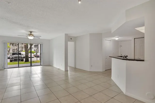 a view of an empty room and kitchen view