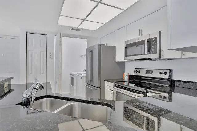 a kitchen with stainless steel appliances a sink a stove and a refrigerator