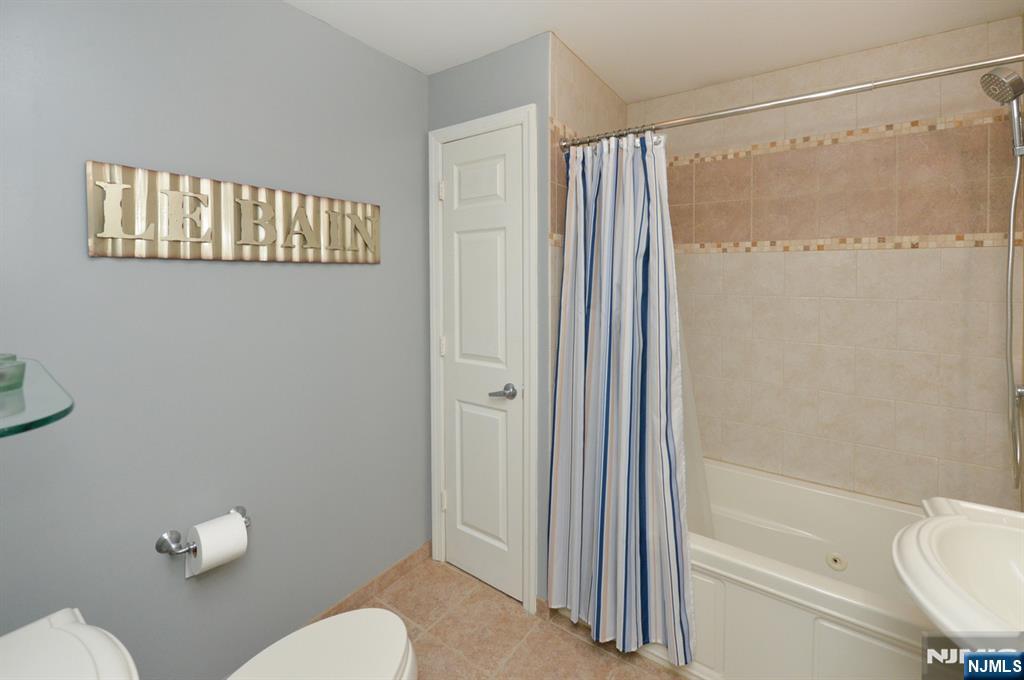 6 Long Avenue Mahwah, NJ 07430 - Photo 24 of 49 a bathroom with a shower curtain a sink and a toilet