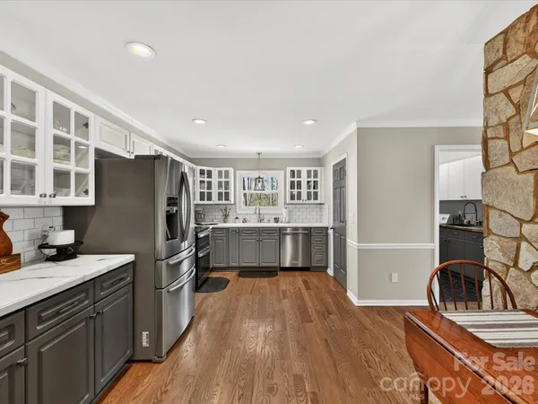 a kitchen with stainless steel appliances granite countertop a refrigerator and a stove top oven