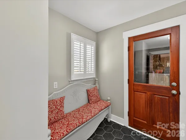 a balcony with wooden floor table and chairs