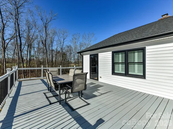 a view of a roof deck with table and chairs and wooden floor
