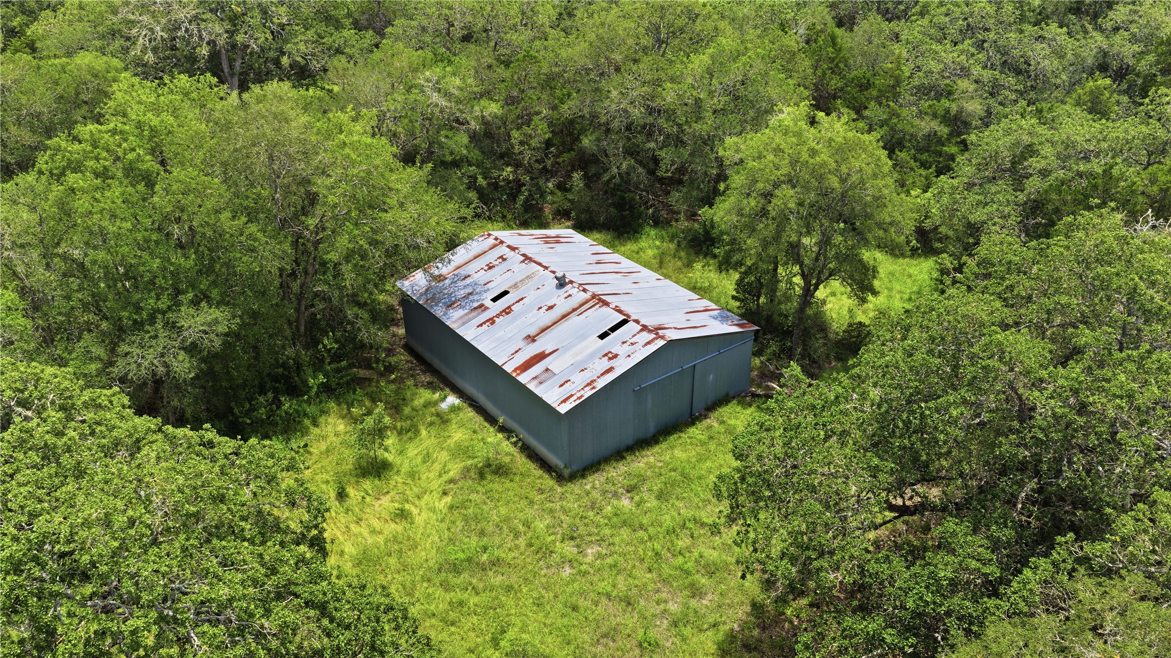 10312 Parsons Road Manor, TX 78653 - Photo 24 of 26 A secluded outbuilding nestled amidst a vibrant, green landscape.