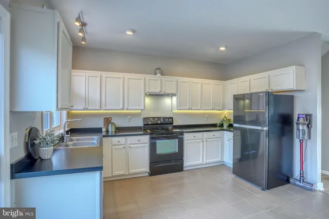 a kitchen with stainless steel appliances granite countertop a refrigerator sink and stove