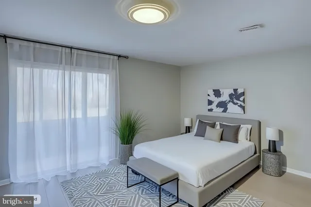 a bedroom with a large bed and a chair