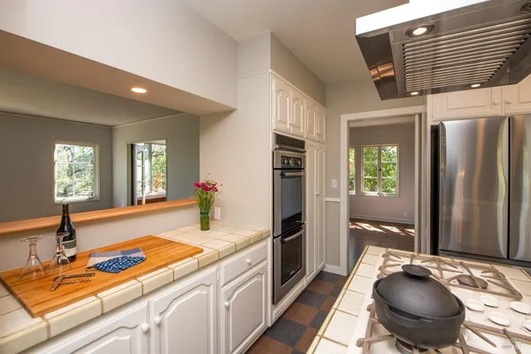 a view of a kitchen with kitchen island granite countertop a sink window and cabinets