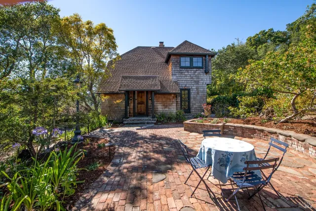 a view of a patio with table and chairs with wooden fence and plants