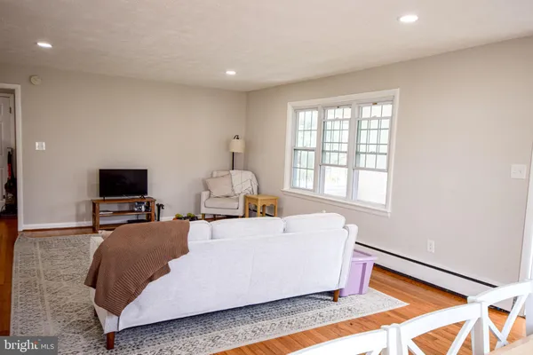 a living room with a bed furniture and a flat screen tv
