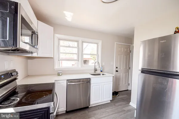 a kitchen with stainless steel appliances a stove microwave and sink