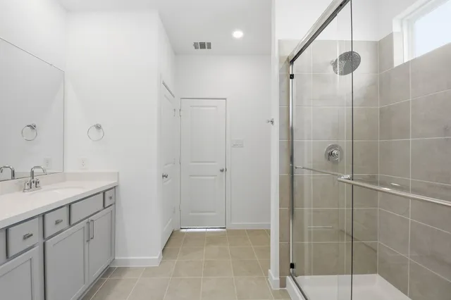 a bathroom with a shower sink vanity and mirror
