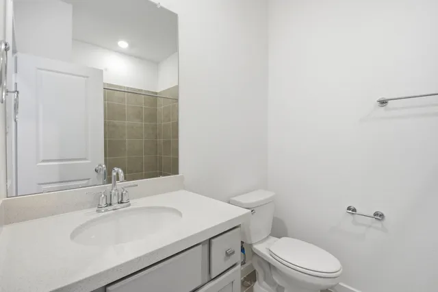 a bathroom with a sink toilet vanity and shower
