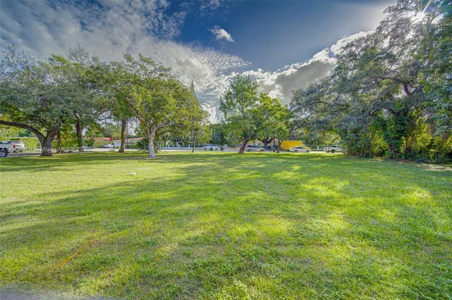 a view of a field with trees in the background