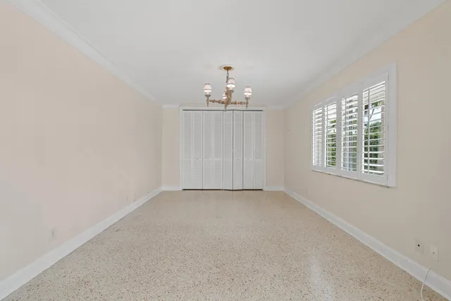 an empty room with chandelier fan